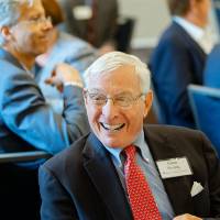 Guest sitting and laughing at the Foundation Annual Meeting